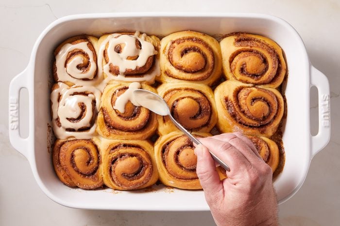drizzling espresso glaze on rolls