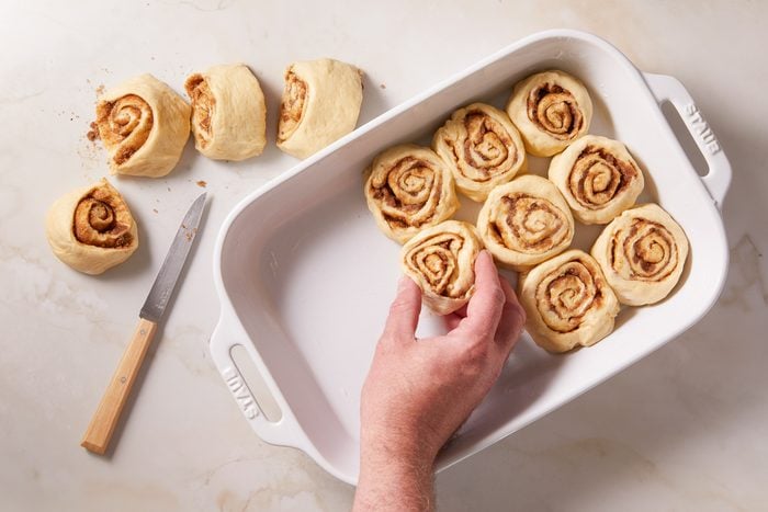 Placing the rolls, cut side down, in a greased 13x9-inch baking pan