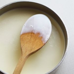 tempered eggs in bowl with wooden spoon