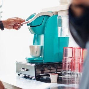 man using a teal Keurig at the office